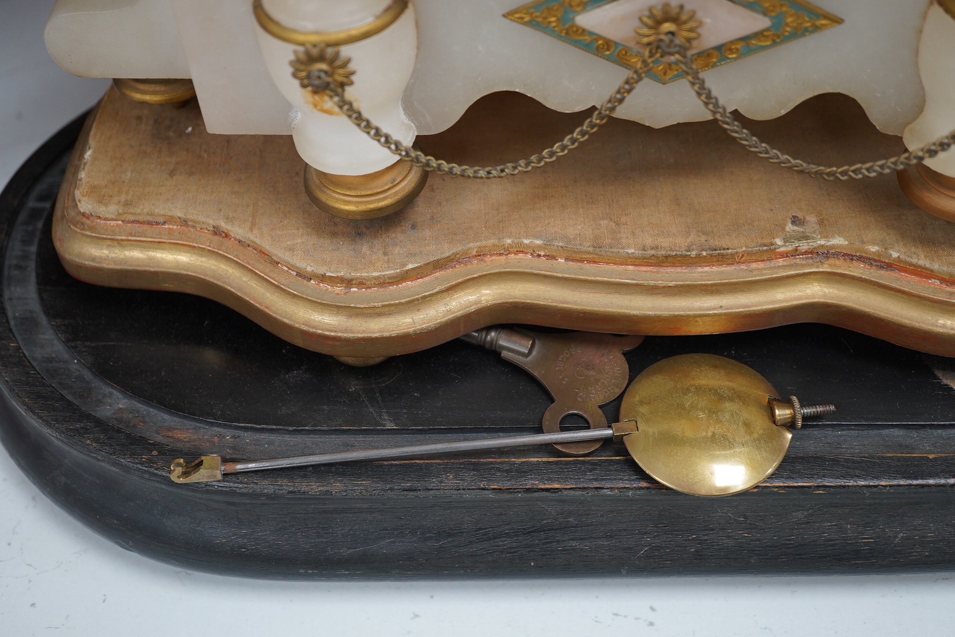 A late 19th century Louis XV style cast gilt spelter figural eight day mantel timepiece on stand, with pendulum and key, 37cm total height. Condition - fair to good, not tested